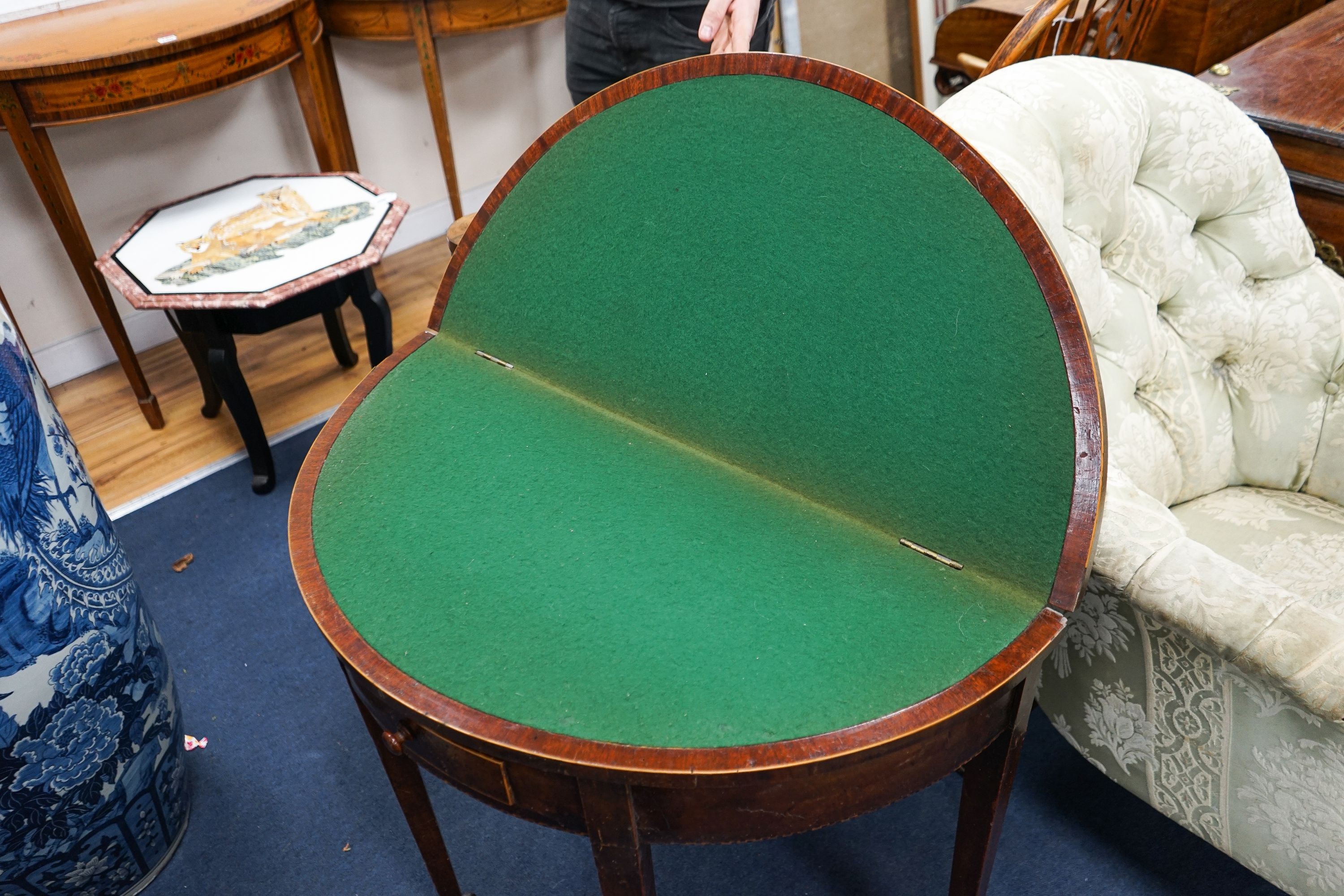 A Georgian mahogany demi-lune card table, with folding top on square tapered legs, width 86cm, depth 41cm, height 71cm